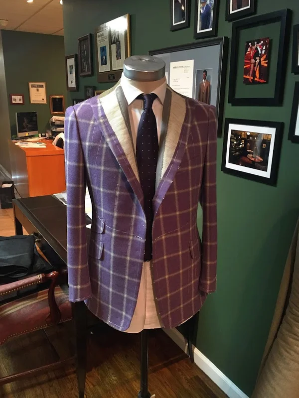 A checked sports jacket with a cream lapel on a stand in the shop.